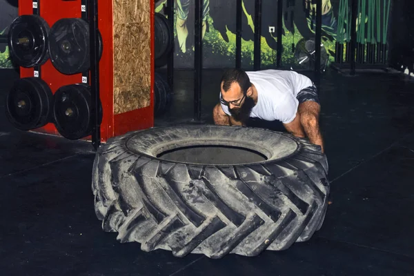Genç sporcu büyük bir lastik dönüyor