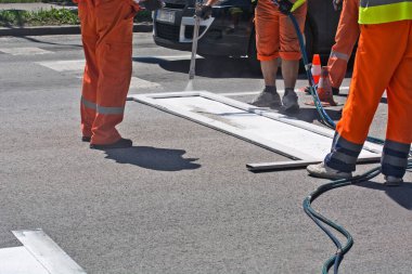 İşçiler bir caddede durak çiziyorlar..