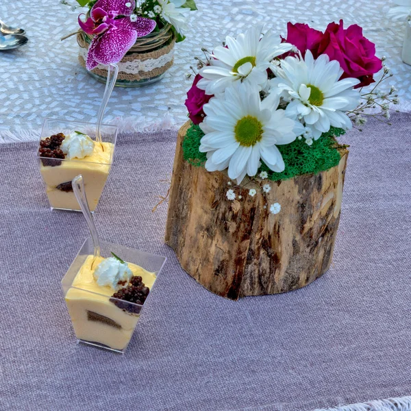 Flowers and pudding placed on the table as decoration. The pudding is prepared for tasting and evaluation, as well as a flower arrangement.