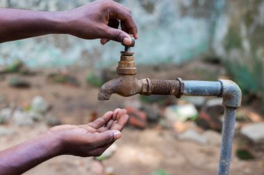 Su krizi Hindistan için ciddi bir tehdittir ve tüm dünyada elini musluğun altında tutan bir adam...