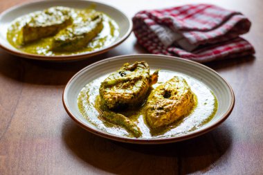 Hardal tohumlu Hilsa köri, keskin hardal ezmesi, baharat ve hardal yağı ile kaynatılmış taze balıkların yer aldığı geleneksel bir Bengali lezzetidir..