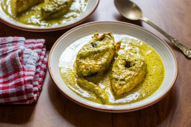 Hardal tohumlu Hilsa köri, keskin hardal ezmesi, baharat ve hardal yağı ile kaynatılmış taze balıkların yer aldığı geleneksel bir Bengali lezzetidir..