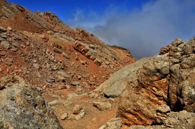 Dağlardaki sarp kayalıklar granit turuncu rengini sisli mavi gökyüzüne karşı