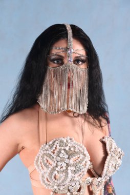 Stüdyoda mavi arka planda doğulu bir resimde güzel bir dansçı.