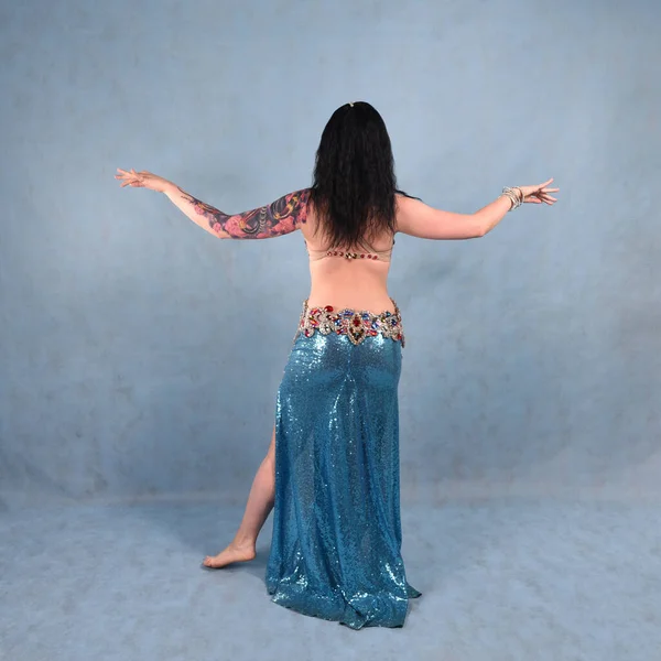 Oryantal elbiseli, duvak takmış, kırmızı etekli, göğüsleri mavi göğüslü güzel bir dansçı.