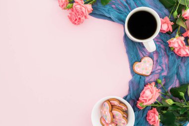 Kahve fincanı kurabiyeyle görünümünü top ve gül çiçek pastel pembe zemin üzerine eşarp