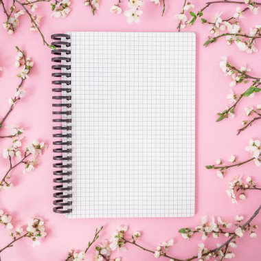 Pastel pembe arka plan üzerinde en iyi görünümü çiçekli ağaç dalları ve defter 