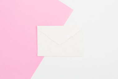 Zarf üstten görünüm pastel pembe ve beyaz arka plan üzerinde