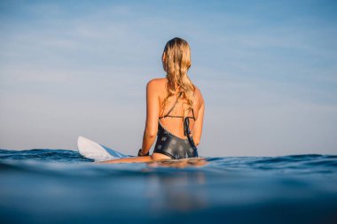 Kadın oturup üzerinde sörf sörf. Okyanusta surfboard ile kadın. Sörfçü ve okyanus