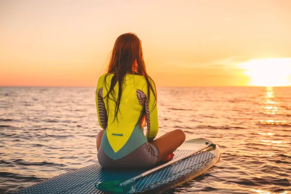 サーフ女性が夕日で海でサーフボードのポーズ — ストック写真