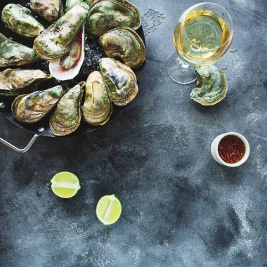 RAW kadeh beyaz şarap ile istiridye ve karanlık masaya limonu. Düz yatıyordu. Üstten görünüm. Gıda çerçeve arka plan