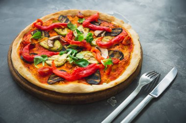 Biber, domates, kabak ve ahşap plaka üzerinde mantar vejetaryen pizza