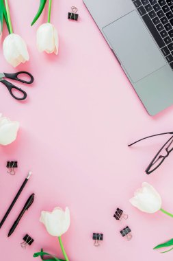 Danışma laptop, beyaz çiçekler, kozmetik, gözlük ve kalem üzerinde pembe bir arka plan ile. Düz yatıyordu. Üstten görünüm. İş kavramı kopya alanı ile