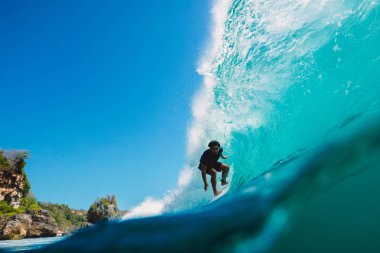 July 7, 2018. Bali, Indonesia. Surfer ride on big barrel wave at Padang Padang, Bali. Professional surfing in ocean clipart