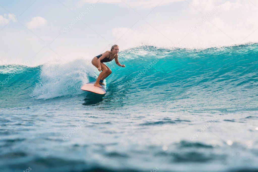 Beautiful surfer girl on surfboard. Woman in ocean during surfing. Surfer and wave