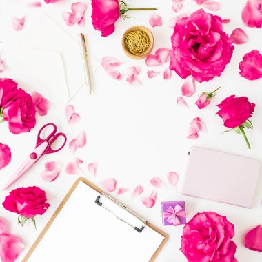 Beyaz arka planda pano, notebook, aksesuar ve pembe çiçekler ile yer iş. Düz yatıyordu, en iyi görünümü.