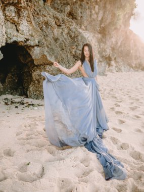 Gündoğumu renkleri, gün batımı ile plajda gri elbiseli kadın portresi.