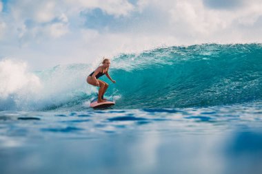 Güzel sörfçü kadın Okyanusu mavi gökyüzü arka plan üzerinde sörf tahtası üzerinde 
