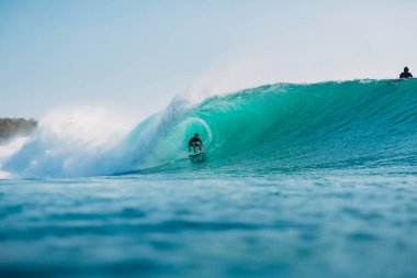 Bali, Endonezya - 29 Temmuz 2018: Sörfçü namlulu tüp dalga mavi okyanus üzerinde 
