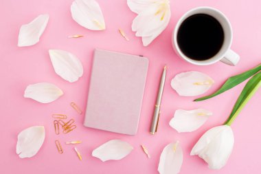 Lale çiçek ve yaprakları fincan kahve ve pembe bir arka plan, üstten görünüm üstünde not etmek ile pastel kompozisyonu.