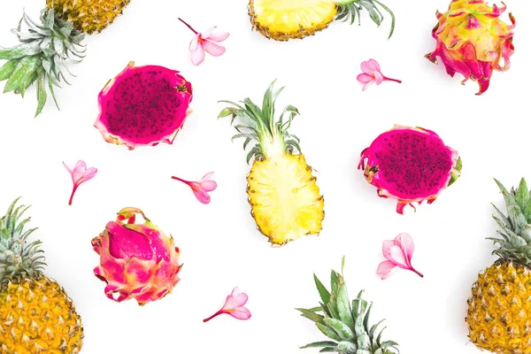 Fruit composition of pineapple and dragon fruits with tropical pink flowers isolated on white background, top view