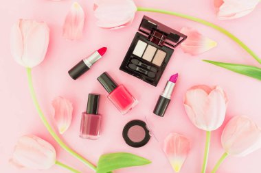 Lale çiçek ve yaprakları ile fincan kahve ve kozmetik pembe arka plan, üstten görünüm üzerinde pastel kompozisyonu.