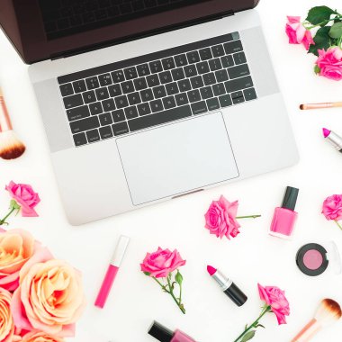 dizüstü bilgisayar ve beyaz arka plan üzerinde üstten görünüm izole kadınsı kozmetik pastel pembe güller
