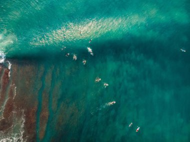 Sörfçü ve mavi okyanus dalgası ile havadan görünümü. Resif üzerinde çökmesini dalga. Üstten görünüm