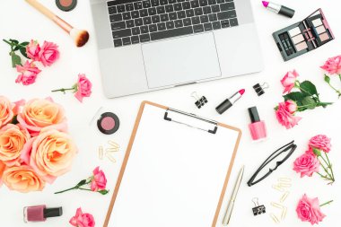 Dizüstü bilgisayar, pano, gül çiçek, kozmetik ve aksesuar beyaz arka plan üzerinde. Düz yatıyordu. Üstten görünüm. Kadınsı freelancer office kavramı