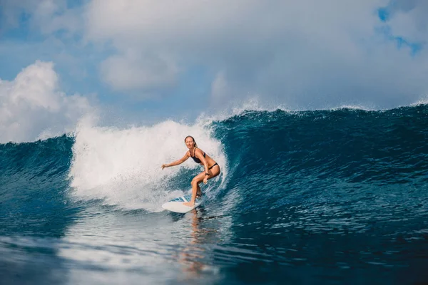 Woman at surfboard ride on wave. Woman in ocean during surfing