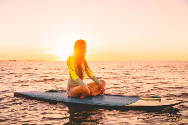 Stand up paddle boarding on a quiet sea with sunset colors. Relax in ocean