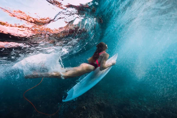 サーフボード ダイビング 水中で大きな波を受けるとサーファーの女の子 — ストック写真