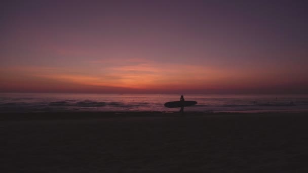 明亮的五颜六色的日落或日出在海滩和海洋与冲浪者 — 图库视频影像