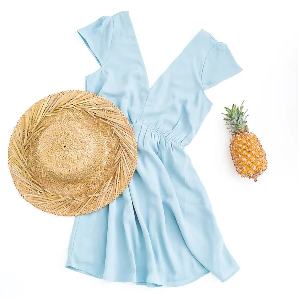 Beyaz arka plan üzerinde ananas meyve ve saman şapkalı kadınsı mavi giyim. Düz yatıyordu, en iyi görünümü.