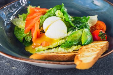Yumurta, somon, avokado, domates ve tost ekmeği, Sezar salatası görünümü kapatın