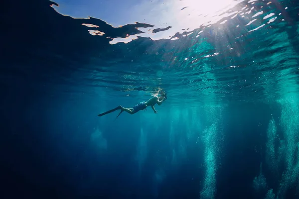Free diver swimming in ocean, underwater photo with diver and bubbles