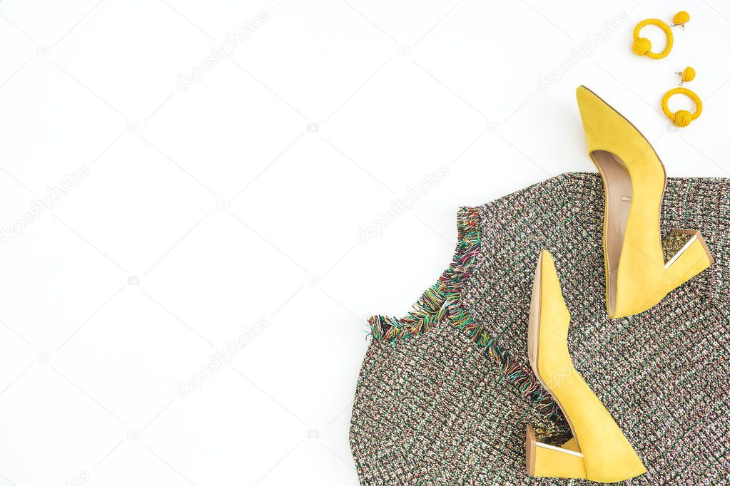 Women fashion cloth and accessories. Female background with yellow shoes, earrings and blouse. Flat lay, top view.