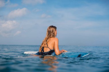 Mayo okyanus izlerken surfboard ile güzel sörfçü kadın. Sörfçü surfboard ile.