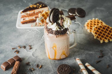 Sos, krema, kurabiye ve kek damlama ile çikolatalı milkshake