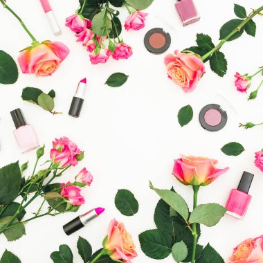 Güzellik çerçeve kompozisyonu ile gül çiçek ve kadınsı beyaz arka plan üzerinde kozmetik makyaj. Düz yatıyordu, en iyi görünümü.