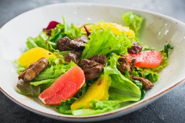 Limon, marul ve bir tabak ızgara tavuk karaciğer ile lezzetli salata. Görünümü kapatın