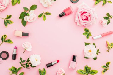 Gül ve makyaj kozmetik pastel pembe bir arka plan üzerinde çerçeve kompozisyonu. Düz yatıyordu, en iyi görünüm. Sevgililer günü