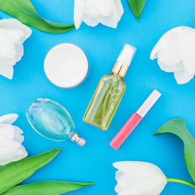 Kadınsı parfüm, ruj, krem, Beyaz Lale çiçek mavi zemin üzerine. Güzellik blogger. Düz yatıyordu, en iyi görünümü