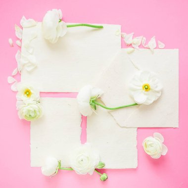Kartpostal Kağıt ve zarf pembe bir arka plan üzerinde beyaz çiçeklerle bileşimi. Düz yatıyordu, en iyi görünümü.