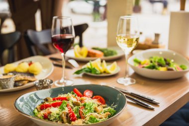 Şenlikli yemeği lezzetli salata, balık yemekleri ve şarap ile. Sağlıklı gıda Cafe