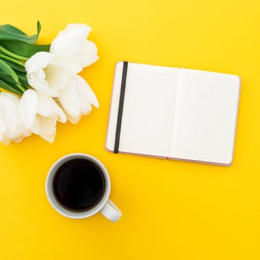 Lale çiçek, kağıt günlüğü ile sarı zemin üzerine kahve bir fincan. Düz yatıyordu, en iyi görünümü.