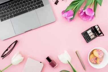 Dizüstü bilgisayar, Lale çiçek gözlük ve çerezler üzerinde pembe bir arka plan ile. Düz yatıyordu. Üstten görünüm. Serbest veya blogger kavramı kopya alanı ile