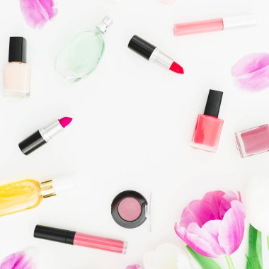 Çerçeve pembe Lale çiçek ve kozmetik, tırnak cilası beyaz zemin üzerine rujla. Üstten görünüm. Düz yatıyordu kadınsı Resepsiyon.