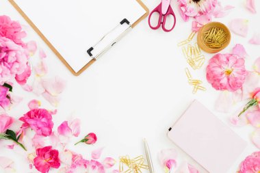 Beyaz arka planda pano, notebook, aksesuar ve pembe çiçekli kompozisyon. Düz yatıyordu, en iyi görünüm. Kopya alanı