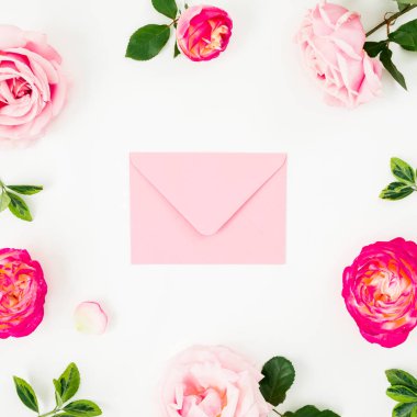 Pembe gül çiçek ve beyaz arka plan üzerinde pembe zarf çerçeve çiçek kompozisyon. Düz yatıyordu, en iyi görünümü